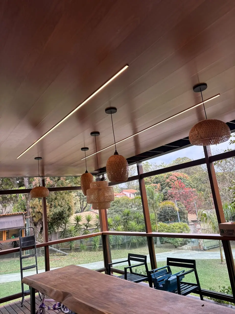 Área gourmet com perfis de LED no forro e pendentes acesos