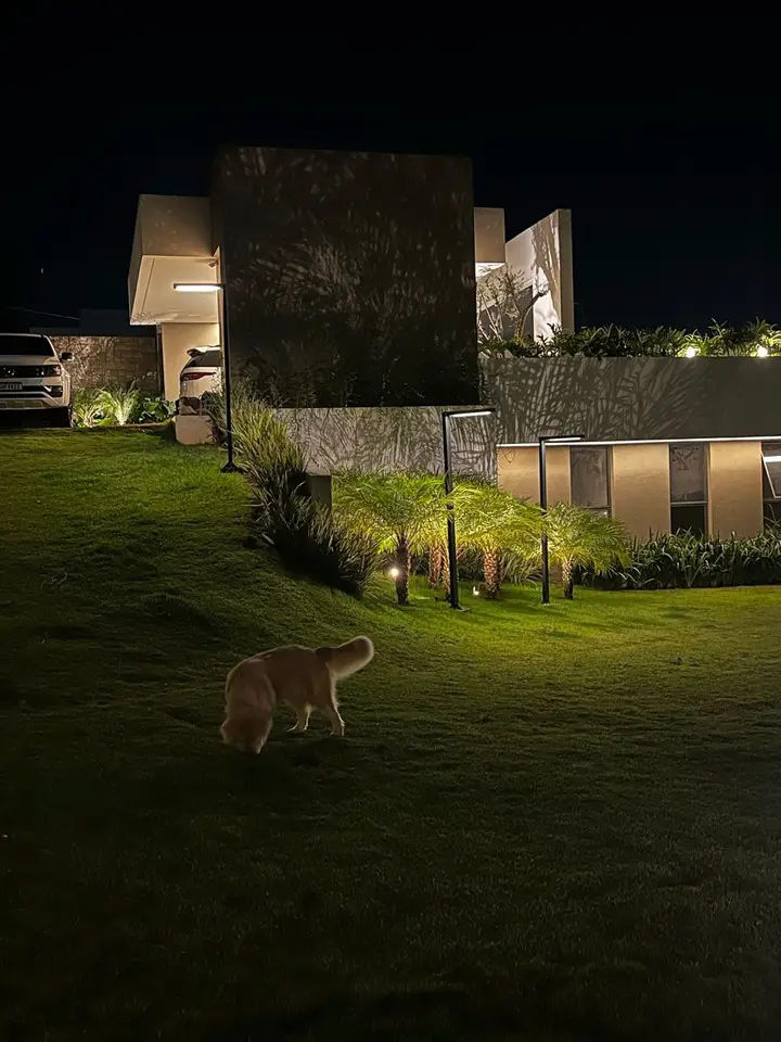 Jardim com balizadores e iluminação externa acesos à noite