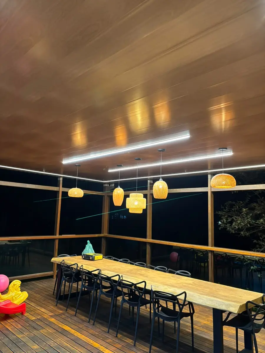 Varanda com perfis de LED e pendentes acesos à noite